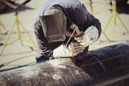 Worker welding a large pipe