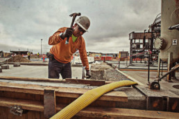Workman with hammer on outdoor construction site