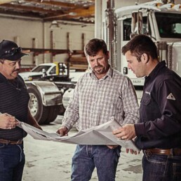 Goebel Management team looking at blueprints