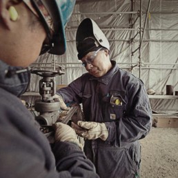 Crew preparing pipe for welding